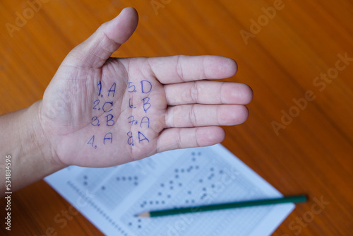 Closeup hand with written numbers and letters .Student write answer on palm.Concept : cheat the test. Dishonest behaviour. Education assessment.    photo