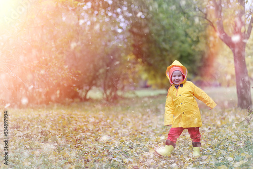 A child in a raincoat for a walk outside in autumn