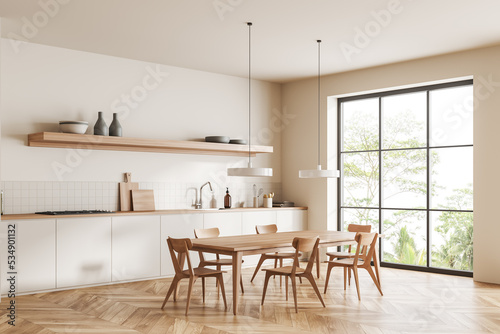 Light kitchen interior with eating table on wooden floor, panoramic window