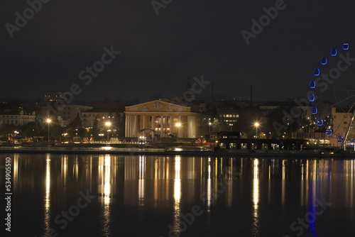 Night landscape with a view of the historic buildings of the city center, evening lights and their perfect reflections in the mirror surface of the bay.