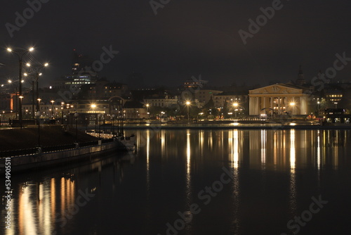 Night landscape with a view of the historic buildings of the city center, evening lights and their perfect reflections in the mirror surface of the bay.