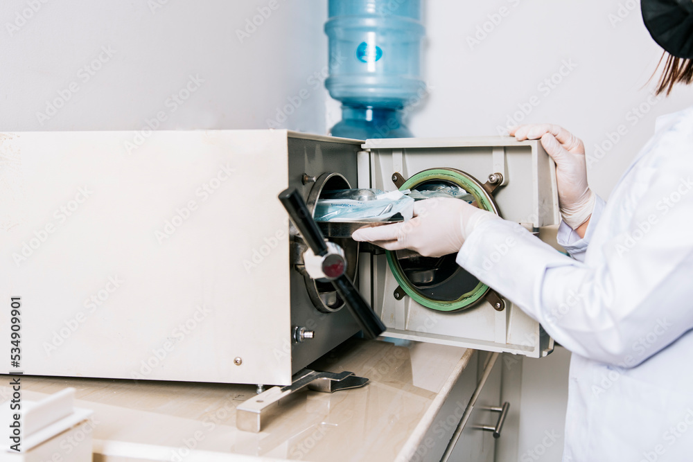 Dentist with dental sterilizer, Dentist hands sterilizing his tools