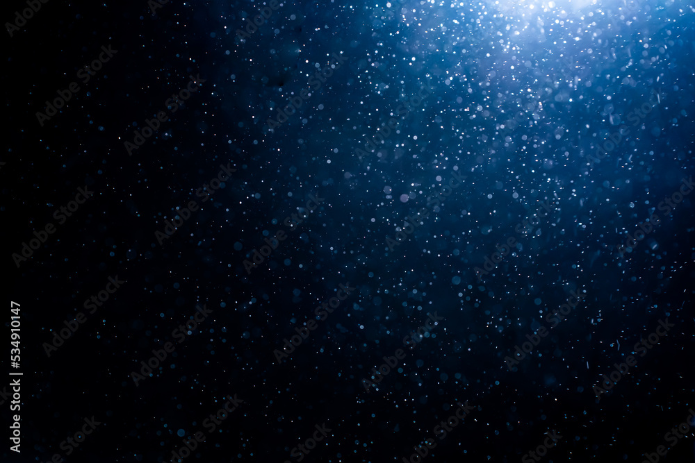 Blue particles on black background with cinematic atmosphere. Glittering sparkling bokeh overlay with copy space for text. - obrazy, fototapety, plakaty 