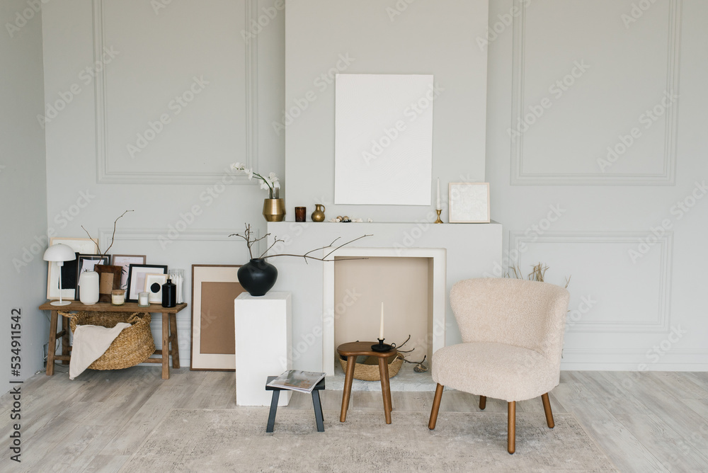 Beautiful interior of a bright minimalist living room with a fireplace and Scandinavian-style armchairs