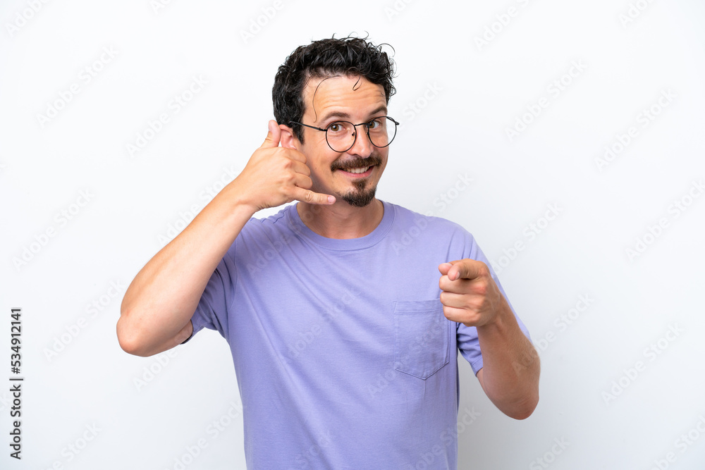 Young man with moustache isolated on white background making phone gesture and pointing front Young man with moustache isolated on white background making phone gesture and pointing front