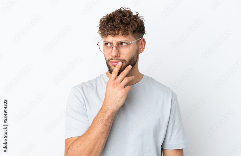 Young handsome caucasian man isolated on white background With glasses and having doubts Young handsome caucasian man isolated on white background With glasses and having doubts