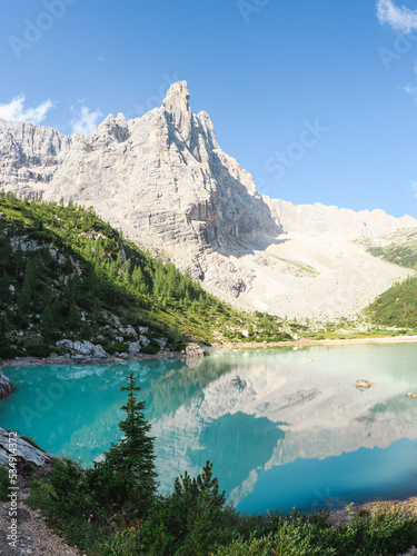 Stunning view of the Lake Sorapis  Lago di Sorapis  with its turquoise waters surrounded by a forest and beautiful rocky mountains  Dolomites  Italy.