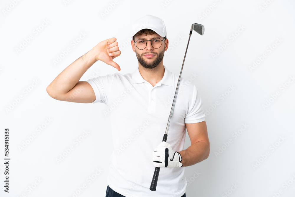 Handsome young man playing golf isolated on white background showing thumb down with negative expression Handsome young man playing golf isolated on white background showing thumb down with negative expression