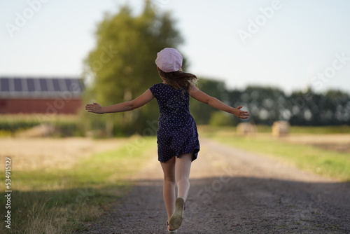 The girl happily runs away along a country road