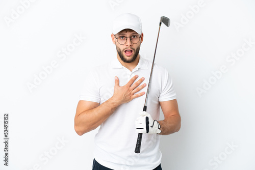 Handsome young man playing golf  isolated on white background surprised and shocked while looking right © luismolinero