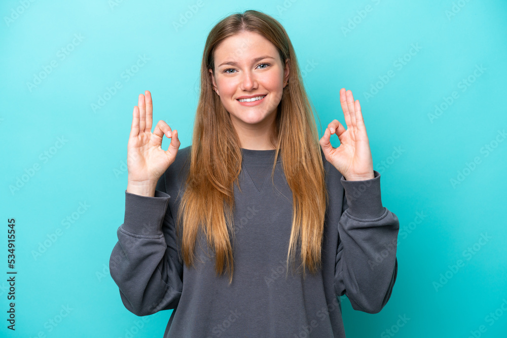 Young caucasian woman isolated on blue background showing ok sign with two hands Young caucasian woman isolated on blue background showing ok sign with two hands
