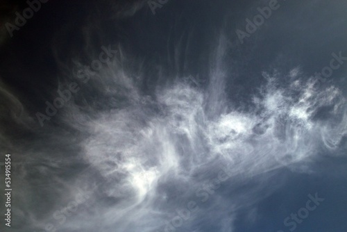 Nube vaporosa y ligera sobre el azul oscuro del cielo. Fondo de escritorio con una imagen dramática e inspiracional.
