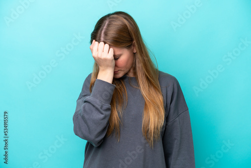 Young caucasian woman isolated on blue background with headache © luismolinero