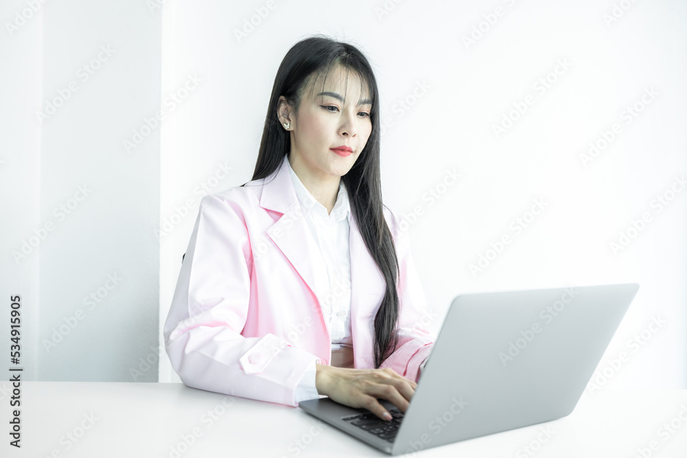 Asian woman doctor using computer laptop on white background, Asian woman doctor in pink coat with computer laptop, Medical and healthcare. Asian woman doctor using computer laptop on white background, Asian woman doctor in pink coat with computer laptop, Medical and healthcare.