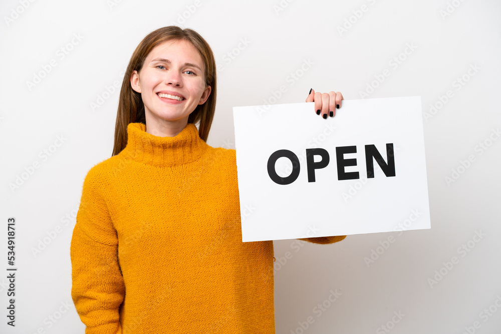 Young English woman isolated on white background holding a placard with text OPEN with happy expression Young English woman isolated on white background holding a placard with text OPEN with happy expression