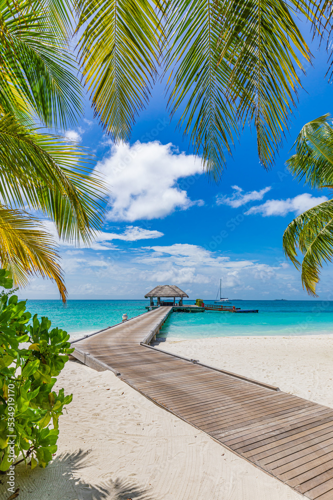 Beautiful tropical Maldives island scene blue sea, blue sky holiday vacation vertical background. Wooden pathway, pier. Amazing summer travel concept. Ocean bay palm trees sandy beach. Exotic nature