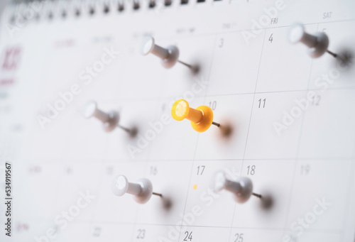 Yellow and white pin on calendar for business meeting and travel planing concept.