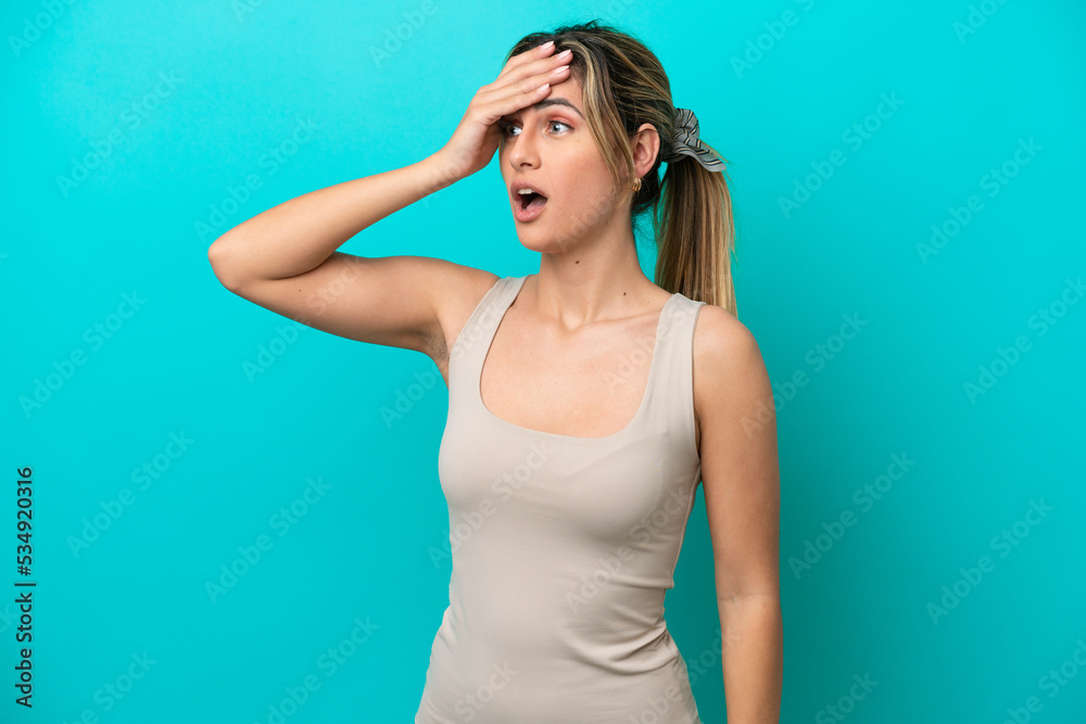 Young caucasian woman isolated on blue background with surprise expression while looking side Young caucasian woman isolated on blue background with surprise expression while looking side