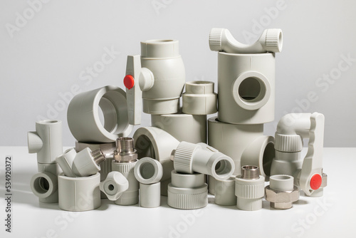 Many polypropylene pipe fittings on the table. photo