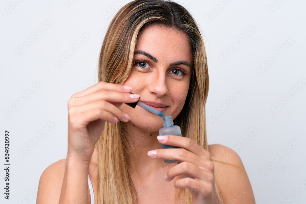 Young caucasian woman isolated on white background holding a serum. Close up portrait Young caucasian woman isolated on white background holding a serum. Close up portrait