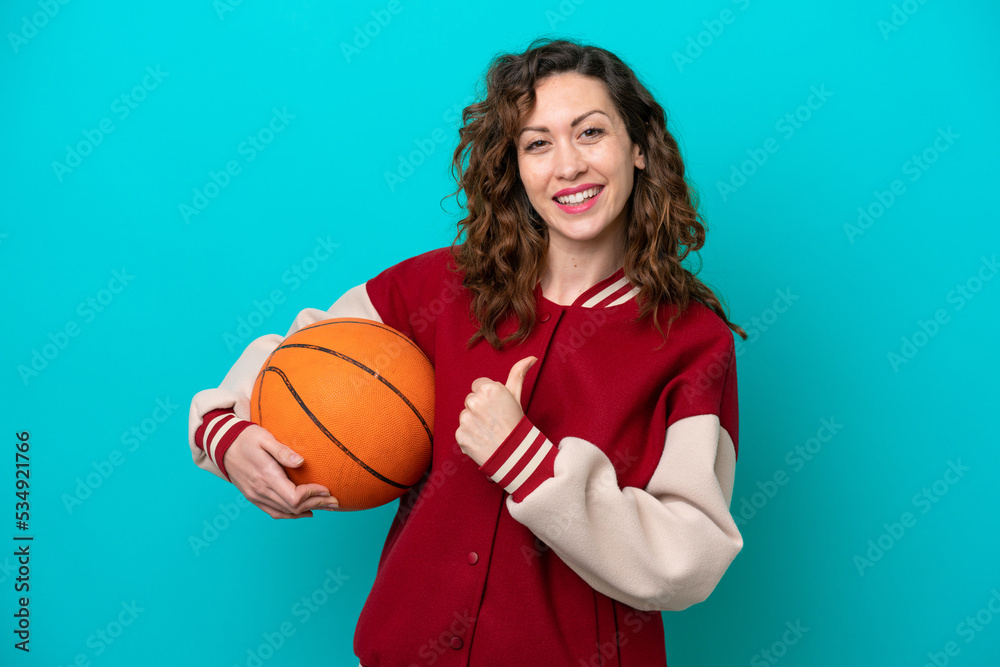 Young caucasian basketball player woman isolated on blue background proud and self-satisfied Young caucasian basketball player woman isolated on blue background proud and self-satisfied