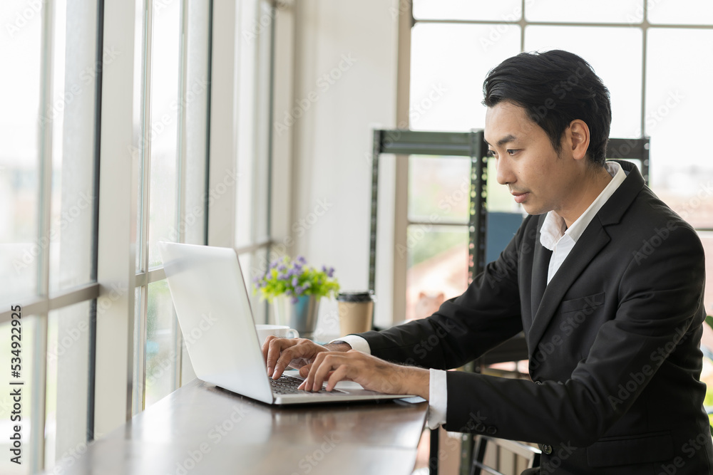 Asian businessman work with computer laptop in the office. Asian business man typing on computer laptop Asian businessman work with computer laptop in the office. Asian business man typing on computer laptop