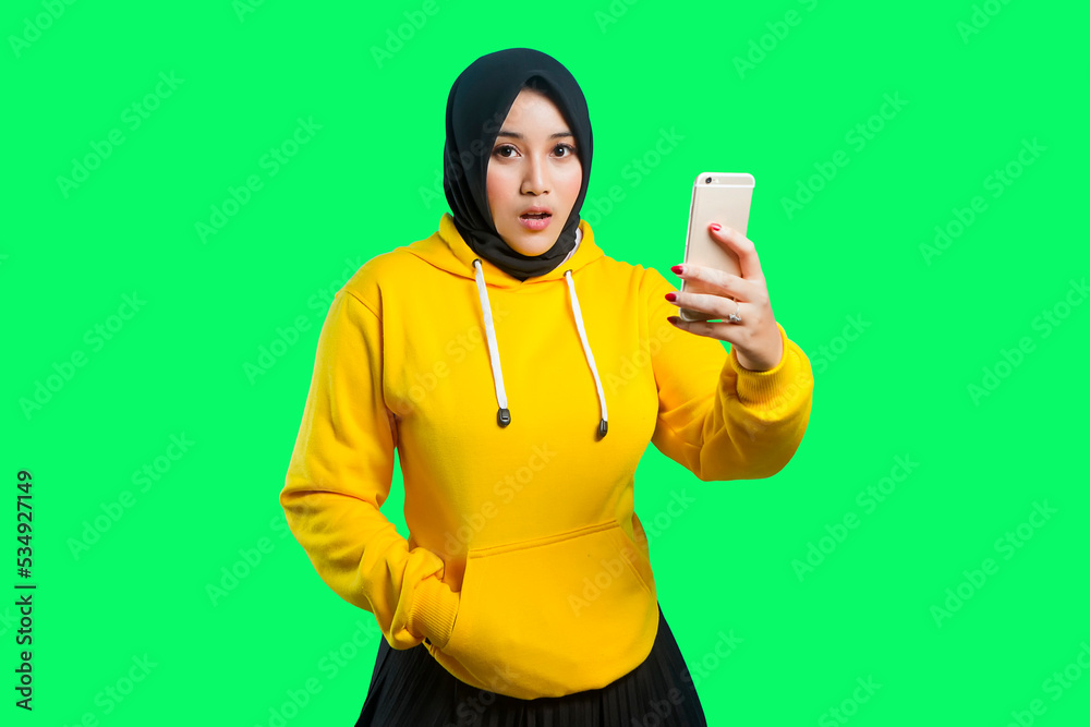 beautiful asian moslem girl with shocked expression and holding her phone beautiful asian moslem girl with shocked expression and holding her phone