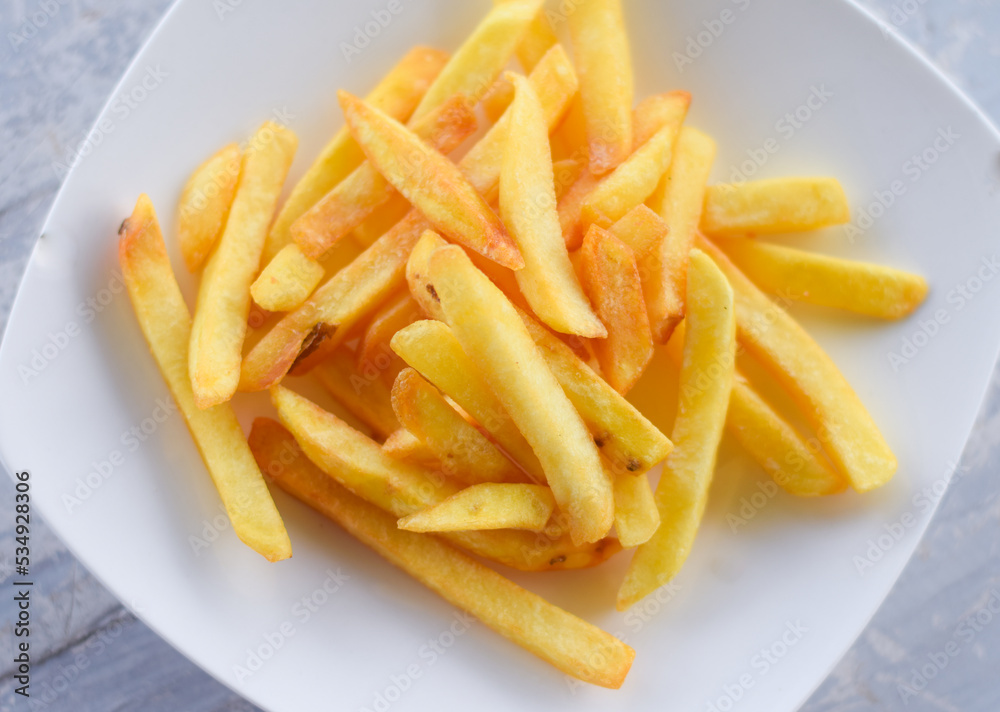 French fries or potato chips on white dish French fries or potato chips on white dish