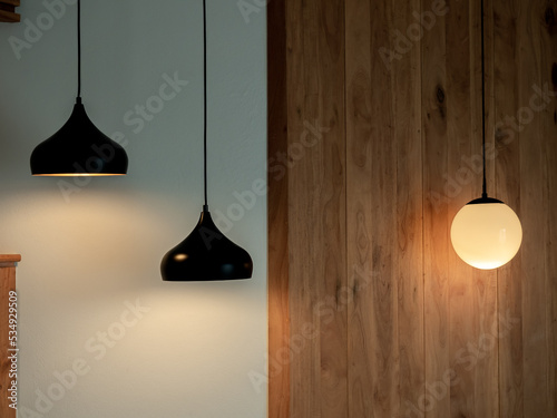 Twin ceiling lighting in the dark room. Two hanging lamp or round ceiling lamp decorated as a steps and round light full moon shape on white and wood wall.
