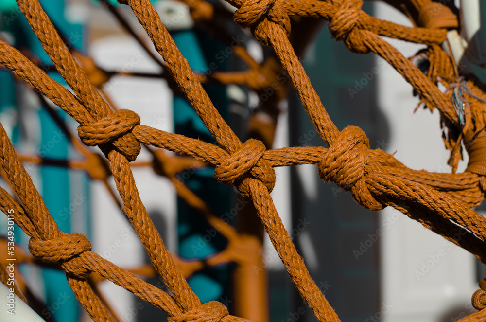 Mesh from an old rope. Climbing rope. Marine knot on a ship. Decorative  fencing. Fishnet. Stock Photo