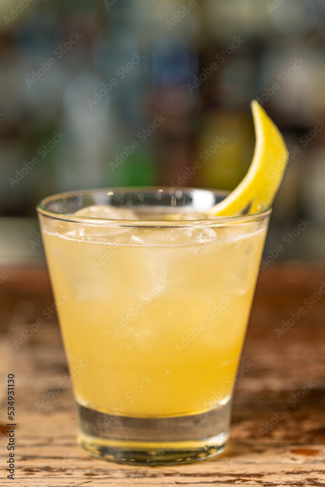 Penicillin cocktail on the bar. Blurred background.Summer refreshing drink, side view Penicillin cocktail on the bar. Blurred background.Summer refreshing drink, side view