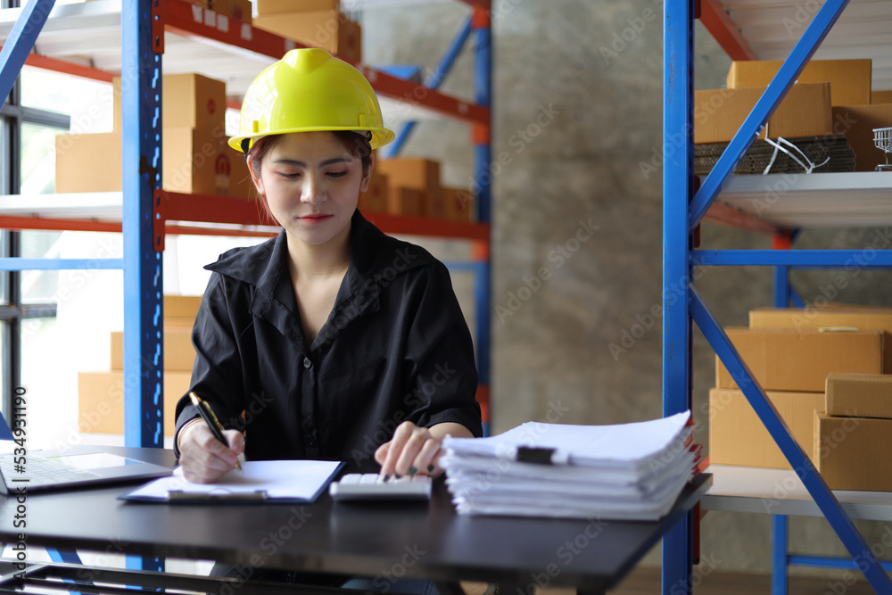 Small warehouse worker working with a laptop is checking the inventory. Entrepreneurs start-up e-commerce businesses working in the office. Small warehouse worker working with a laptop is checking the inventory. Entrepreneurs start-up e-commerce businesses working in the office.