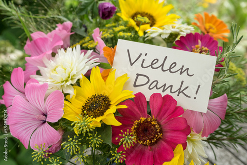 Colorful bouquet of summer flowers with card and German text: Many Thanks 
