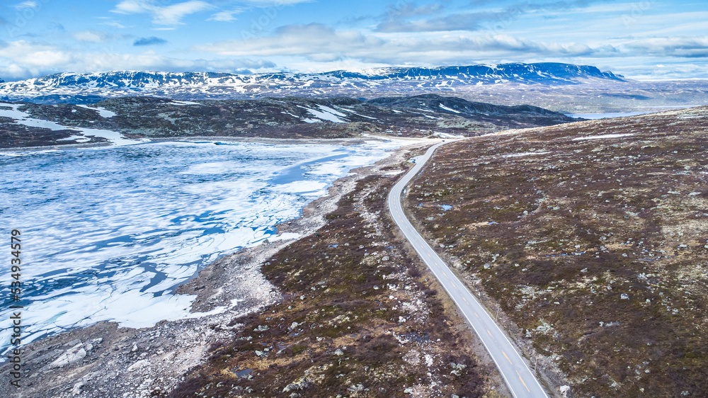 Spectacular aerial view of the Hardangervidda mountain road and area with snow and melting ice on the lakes