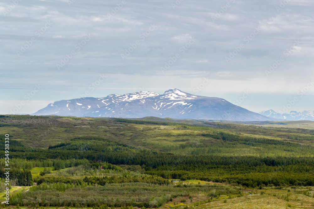 a panoramic view over the grassland and mountains at the region of  Bláskógabyggð, iceland
