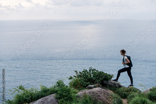Athletes running on a forest path against the sea in the background. Looking at the clock. Health concept jogging fitness woman.