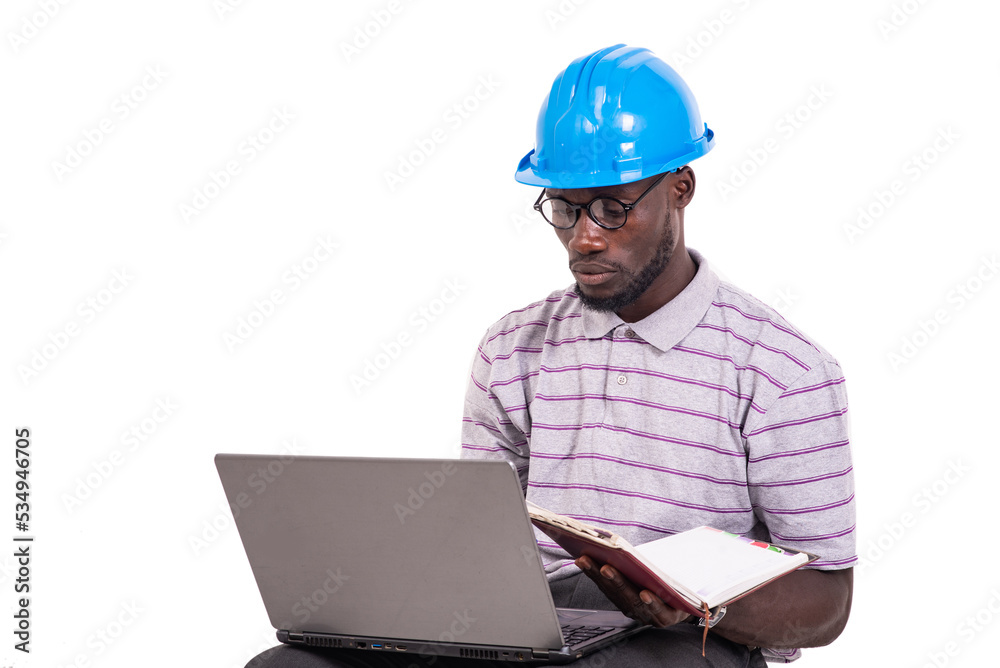young man engineer checking the notes in a notebook using a laptop. young man engineer checking the notes in a notebook using a laptop.