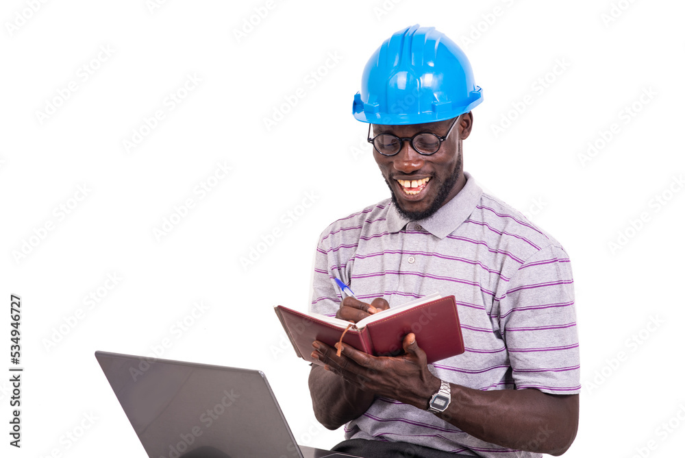 young man engineer writing in a notebook using a laptop. young man engineer writing in a notebook using a laptop.
