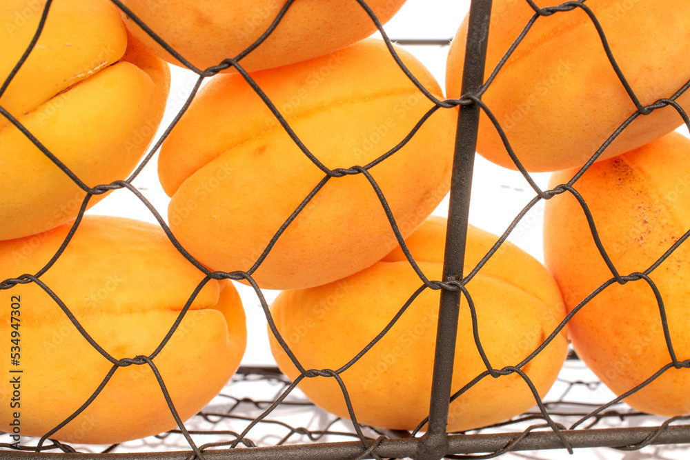 Obraz premium Several bright yellow juicy pineapple apricots in a basket, macro isolated on a white background. 