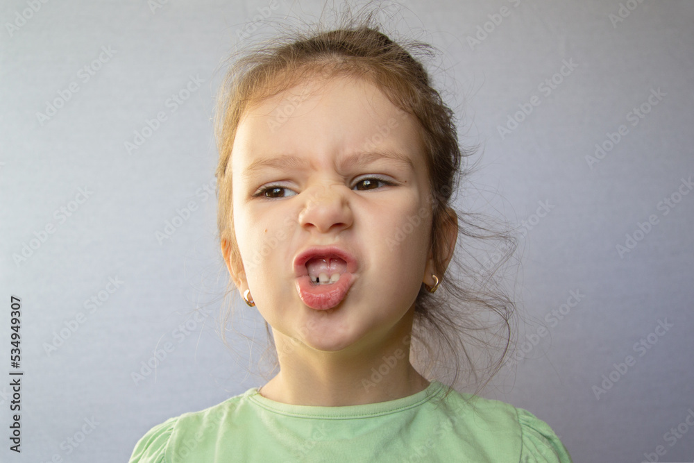 a girl of four diligently opens her lips. speech training