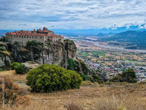 Scenic view of Holy Monastery of St Stephen (Agios Stephanos monastery) near Kalambaka, Meteora, Thessaly, Greece, Europe. Orthodox landmark build on unique rock formation. Pineios river in valley photo