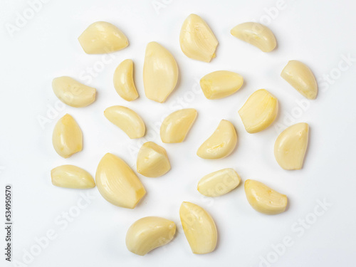Set of peeled garlic on white background top view.