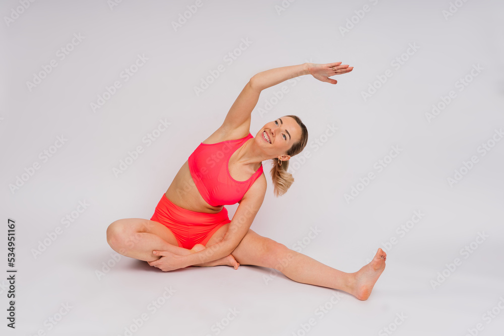 Full length portrait of smiling young woman in sportswear isolated over studio background. Full length portrait of smiling young woman in sportswear isolated over studio background.