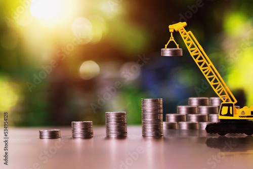 Construction cranes are stacking coins. business investment ideas