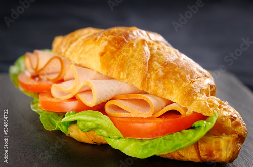 ham and cheese croissant on black slate board (ID: 534954722)