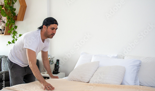 Young man making the bed
