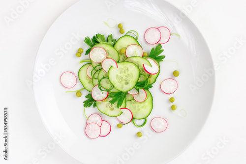 Cucumber and radish salad on a white plate (ID: 534958574)