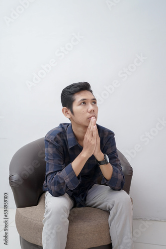 man wearing plaid shirt sitting and confused about something