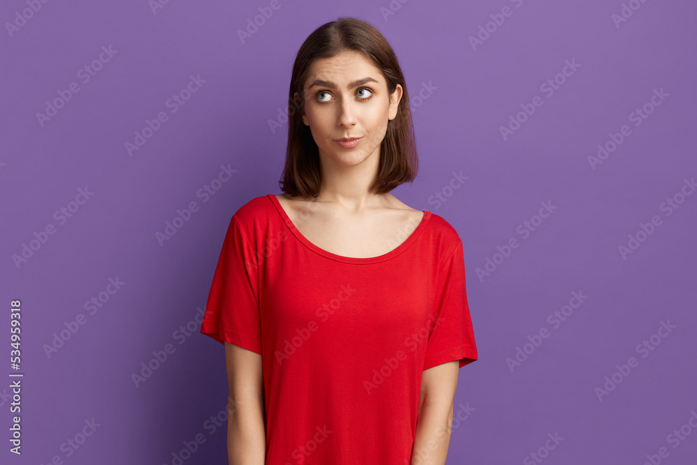 Oops, my bad. Confused pretty brunette girl in red t-shirt feeling awkward, lifting eyebrows and looking up. Looks very upset after making mistake and being guilty Posing over purple background. Oops, my bad. Confused pretty brunette girl in red t-shirt feeling awkward, lifting eyebrows and looking up. Looks very upset after making mistake and being guilty Posing over purple background.