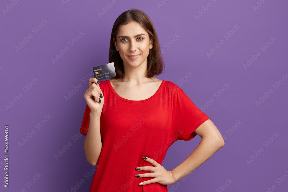 I like cashback. Advertising of your bank. Happy young pretty brunette girl in red t-shirt showing debit or credit card. Posing over purple wall. Using e-banking, e-commerce. Cashless money. I like cashback. Advertising of your bank. Happy young pretty brunette girl in red t-shirt showing debit or credit card. Posing over purple wall. Using e-banking, e-commerce. Cashless money.